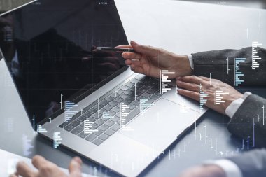 İki tüccar dizüstü bilgisayar kullanarak borsa davranışlarını tahmin etmek için tarihi verileri araştırıyor. İnternet ticareti konsepti. Eski ve finansal hologram şeması. Tahmin ve planlama.