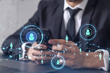 Uluslararası takımı işe alacak en iyi adayları bulmak için sosyal ağları akıllı telefonlarla tarayan insan kaynakları uzmanlarının elleri. Başarı kavramı. Medya hologram simgeleri. Resmi giysi.