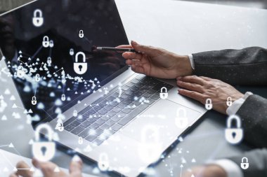 Bilgisayar kullanarak uluslararası şirketin siber güvenliğini sağlamak için projede çalışan iki iş adamı. Asma kilit hologram simgeleri. Takım çalışması konsepti.