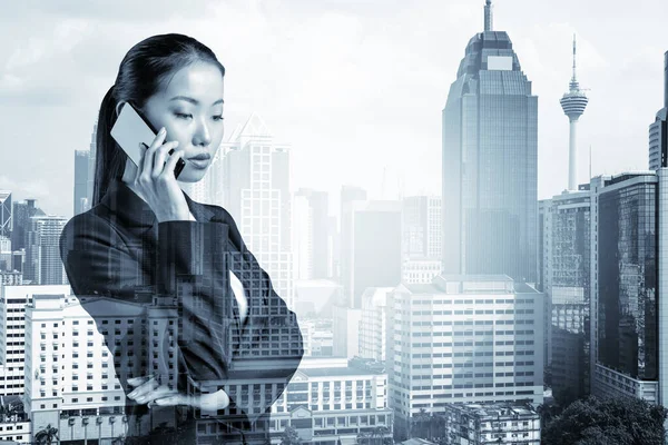 Процвітаюча дівчина азіатського бізнесу в костюмі енергійно розмовляюча по телефону, Куала-Лумпур. Концепція консультантів як розв'язувачів проблем. KL skyscrapers Подвійний вплив. — стокове фото