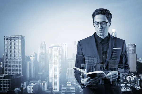 Joven hombre de negocios guapo en traje y gafas pensando en cómo abordar el problema, nuevas oportunidades de carrera, asignación de MBA. Bangkok en el fondo. Doble exposición. — Foto de Stock