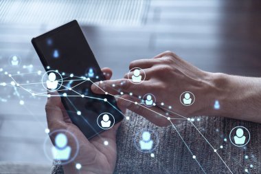 Uluslararası takımı işe alacak en iyi adayları bulmak için sosyal ağları akıllı telefonlarla tarayan insan kaynakları uzmanlarının elleri. Başarı kavramı. Ortam hologramı simgeleri.