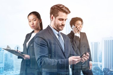 Takım elbiseli üç iş arkadaşından oluşan bir grup yeni kariyer fırsatları elde etmek için proje üzerinde birlikte çalışıyorlar. Çok uluslu şirket takımı kavramı. Kuala Lumpur. Çift pozlama.