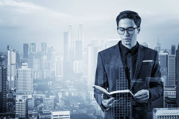 Joven hombre de negocios guapo en traje y gafas pensando en cómo abordar el problema, nuevas oportunidades de carrera, asignación de MBA. Kuala Lumpur en el fondo. Doble exposición. — Foto de Stock