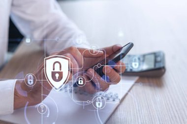 Bir programcı, bir siber güvenliği hacker saldırılarından korumak ve müşterilerinin gizli verilerini kaydetmek için akıllı telefonuyla internete giriyor. Hologram simgelerini daktilo eden ellerin üzerine kilitle. Resmi giysi.