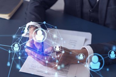 Potansiyel bir çalışan, kariyerini ilerletmek ve kişisel gelişimde yeni fırsatlar elde etmek için sözleşmeyi okurken resmi olarak giyiniyor. Akıllı telefondan anlaşmanın detaylarını kontrol ediyorum. Sosyal medya hologram simgeleri
