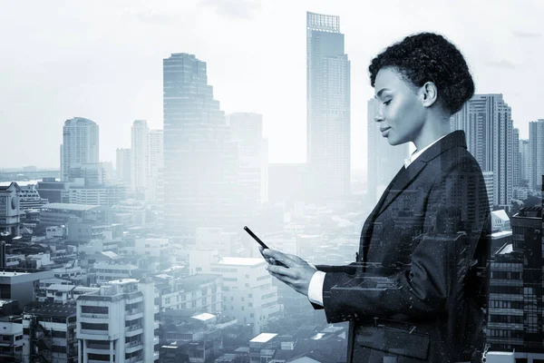 Приваблива чорна афроамериканська бізнес-жінка в костюмі використовуючи смартфон і думаючи, як впоратися з проблемою, нові можливості кар'єри, MBA. Бангкок на задньому плані. Подвійний вплив. — стокове фото