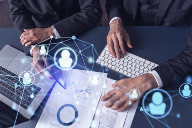 İki İK uzmanı, uluslararası danışmanlık şirketindeki stajyerlik programını geliştirmek için mezunlar pazarını inceliyor. Yeni yetenekli memurlar işe almak. Sosyal medya hologram simgeleri.