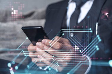 Programcı elinde akıllı bir telefon tutuyor ve tamamen yeni bir hizmet sunmak için yenilikçi bir uygulamayı test ediyor. Yakın çekim. Hologram teknik grafikleri. Dev takım kavramı. Resmi giysi.
