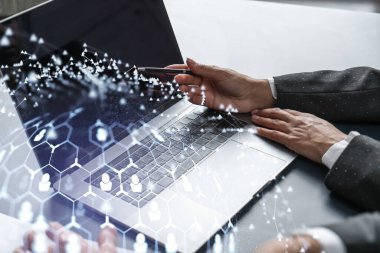İki İK uzmanı, uluslararası danışmanlık şirketindeki stajyerlik programını hızlandırmak için dizüstü bilgisayar kullanarak işe alım pazarını inceliyor. Sosyal ağ hologram simgeleri.