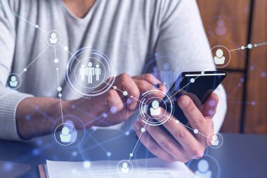 Uluslararası takımı işe alacak en iyi adayları bulmak için sosyal ağları akıllı telefonlarla tarayan insan kaynakları uzmanlarının elleri. Başarı kavramı. Ortam hologramı simgeleri.