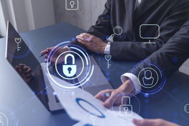 Bilgisayar kullanarak uluslararası şirketin siber güvenliğini sağlamak için projede çalışan iki iş adamı. Asma kilit hologram simgeleri. Takım çalışması konsepti.