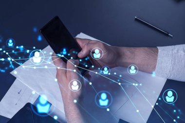 Uluslararası takımı işe alacak en iyi adayları bulmak için sosyal ağları akıllı telefonlarla tarayan insan kaynakları uzmanlarının elleri. Başarı kavramı. Ortam hologramı simgeleri.