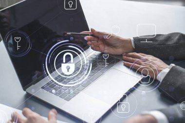 Bilgisayar kullanarak uluslararası şirketin siber güvenliğini sağlamak için projede çalışan iki iş adamı. Asma kilit hologram simgeleri. Takım çalışması konsepti.