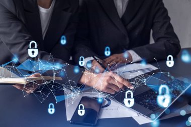 Uluslararası şirketin siber güvenliğini korumak için projede çalışan iki iş kadını. Belgelerle birlikte masadaki Hologram simgelerini kilitle.