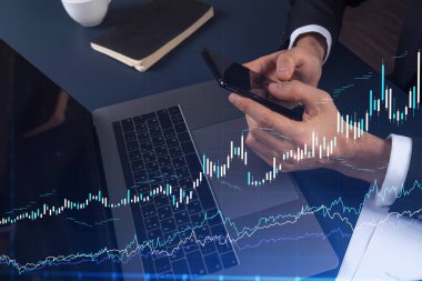 Elinde akıllı bir telefon tutan tüccar doğru yatırım çözümlerine ulaşmak için borsayı araştırıyor. İnternet ticareti ve zenginlik yönetimi kavramı. Hologram Forex grafiği yakın çekim üzerine.