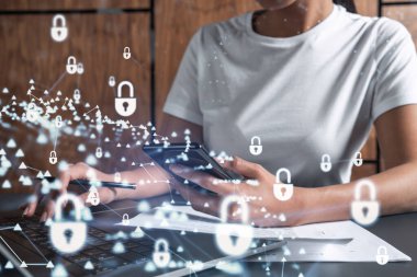 Bir kadın programcı bilgisayar üzerinden bir siber güvenliği korsan saldırılarından korumak ve müşterilerin gizli bilgilerini kaydetmek için kod yazıyor. Hologram simgelerini daktilo eden ellerin üzerine kilitle. Günlük kıyafet..