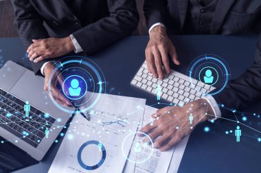 İki İK uzmanı, uluslararası danışmanlık şirketindeki stajyerlik programını geliştirmek için mezunlar pazarını inceliyor. Yeni yetenekli memurlar işe almak. Sosyal medya hologram simgeleri.