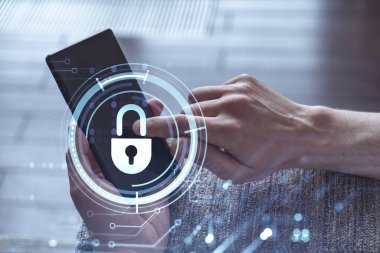 Bir programcı, bir siber güvenliği hacker saldırılarından korumak ve müşterilerinin gizli verilerini kaydetmek için akıllı telefonuyla internete giriyor. Yazan ellerin üzerine asma kilit hologramı simgeleri.