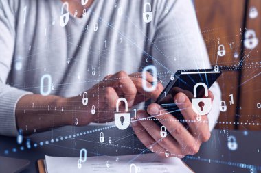 Bir programcı, bir siber güvenliği hacker saldırılarından korumak ve müşterilerinin gizli verilerini kaydetmek için akıllı telefonuyla internete giriyor. Yazan ellerin üzerine asma kilit hologramı simgeleri.