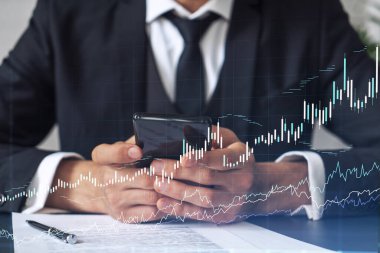 Resmi çalışan bir müşteri borsaya yatırım yapmak için sözleşmeyi okuyor. İnternet ticareti ve zenginlik yönetimi kavramı. Akıllı telefondaki aktarım detayları denetleniyor.