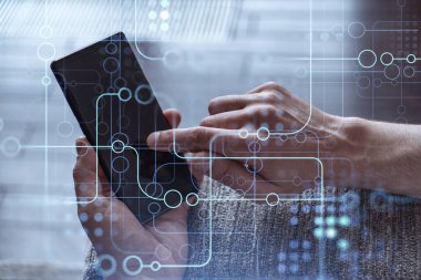 Programcı elinde akıllı bir telefon tutuyor ve tamamen yeni bir hizmet sunmak için yenilikçi bir uygulamayı test ediyor. Yakın çekim. Hologram teknik grafikleri. Dev takım kavramı.