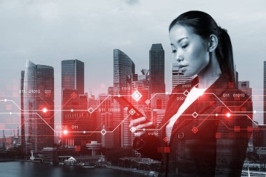 Akıllı telefondan interneti araştırarak yeni teknolojik yaklaşımlar kullanarak ticarette muazzam bir büyüme sağlamaya çalışan çekici Asyalı iş kadını. Singapur üzerinde teknik hologram simgeleri