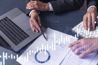 Borsa davranışlarını tahmin etmek için tarihi verileri araştıran iki tüccar ve kadın. İnternet ticareti konsepti. Belgelerin olduğu masanın üzerinde eski ve finansal hologram şeması
