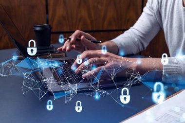 Bir programcı bir siber güvenliği bilgisayar korsanlarından korumak ve müşterilerin gizli bilgilerini kaydetmek için klavyeye kod yazıyor. Yazan ellerin üzerine asma kilit hologramı simgeleri.