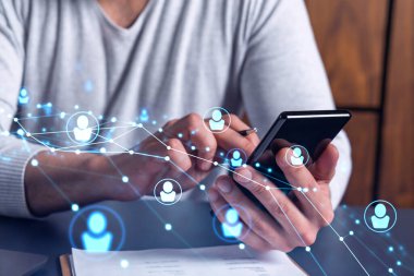 Uluslararası takımı işe alacak en iyi adayları bulmak için sosyal ağları akıllı telefonlarla tarayan insan kaynakları uzmanlarının elleri. Başarı kavramı. Ortam hologramı simgeleri.