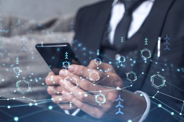 Programcı elinde akıllı bir telefon tutuyor ve tamamen yeni bir hizmet sunmak için yenilikçi bir uygulamayı test ediyor. Yakın çekim. Hologram teknik grafikleri. Dev takım kavramı. Resmi giysi.