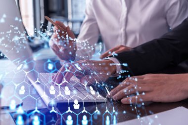 İki İK uzmanı, uluslararası danışmanlık şirketindeki stajyerlik programını hızlandırmak için dizüstü bilgisayar kullanarak işe alım pazarını analiz ediyor. Sosyal ağ hologram simgeleri.