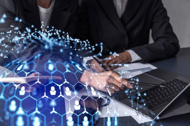 İki İK uzmanı, uluslararası danışmanlık şirketinin stajyer programını geliştirmek için çömezlerin pazarını inceliyor. Yeni yetenekli bir ekip işe alıyorum. Sosyal medya hologram simgeleri. Kadınlar iş başında.