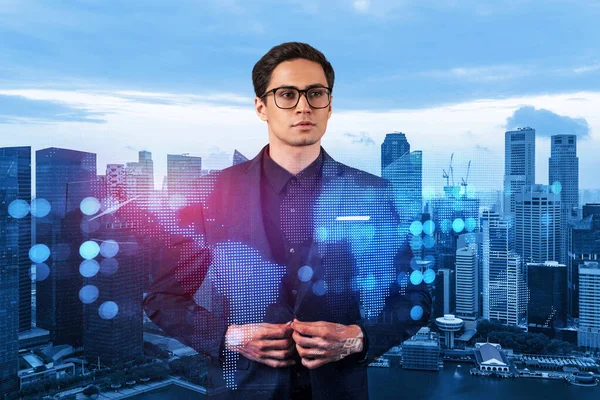 Handsome eastern HR director at international company is thinking about efficient strategy to recruit highly qualified specialists. Social media and marketing hologram icons over Singapore background.