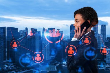 Çekici siyah siber güvenlik geliştiricisi müşterileri gizli bilgilerden korumak için telefon kullanarak yeni yaklaşımlar keşfediyor. Singapur şehir arkaplanı üzerinde sosyal medya simgeleri.