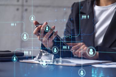 İş kadını resmi olarak, kariyerini ilerletmek ve kişisel gelişimde yeni fırsatlar elde etmek için iş sözleşmesini imzalamak üzere telefonu kontrol ederken giyiniyor. Başarı kavramı. Sosyal medya hologram simgeleri