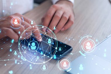 Uluslararası takımı işe alacak en iyi adayları bulmak için sosyal ağları akıllı telefonlarla tarayan insan kaynakları uzmanlarının elleri. Başarı kavramı. Medya hologram simgeleri. Resmi giysi.