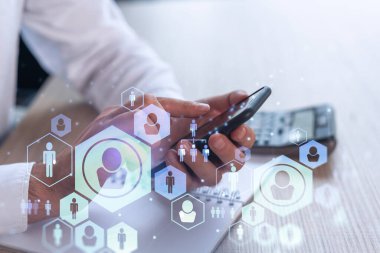 Uluslararası takımı işe alacak en iyi adayları bulmak için sosyal ağları akıllı telefonlarla tarayan insan kaynakları uzmanlarının elleri. Başarı kavramı. Medya hologram simgeleri. Resmi giysi.
