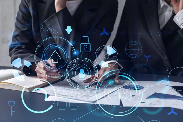 Two information technology specialist brainstorming on project to create a new approach to develop software to improve business service. Technological icons over the table with document.