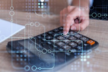 Yüksek teknoloji sektörünü geliştirmek için yeni bir yaklaşım yaratmak için verileri hesaplayan bir araştırma ve geliştirme uzmanı. Masanın üzerinde hesap makineli teknoloji simgeleri var. Kadın eli.