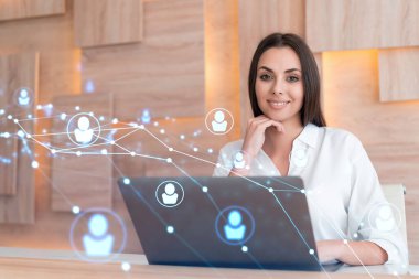 İş yerindeki beyaz gömlekli çekici iş kadını uluslararası iş danışmanlığı için yeni çalışanlar arıyor. İK ve sosyal medya hologram simgeleri ofis arka planında