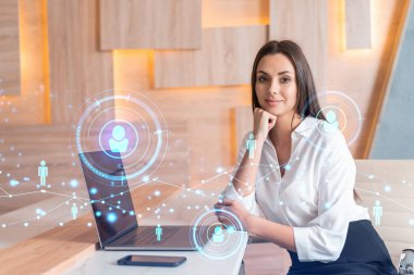 İş yerindeki beyaz gömlekli çekici iş kadını uluslararası iş danışmanlığı için yeni çalışanlar arıyor. İK ve sosyal medya hologram simgeleri ofis arka planında