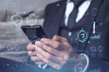 Programcı elinde akıllı bir telefon tutuyor ve tamamen yeni bir hizmet sunmak için yenilikçi bir uygulamayı test ediyor. Yakın çekim. Hologram teknik grafikleri. Dev takım kavramı. Resmi giysi.