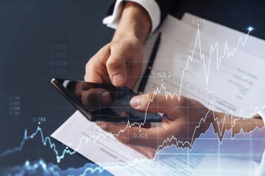 Resmi çalışan bir müşteri borsaya yatırım yapmak için sözleşmeyi okuyor. İnternet ticareti ve zenginlik yönetimi kavramı. Akıllı telefondaki aktarım detayları denetleniyor.