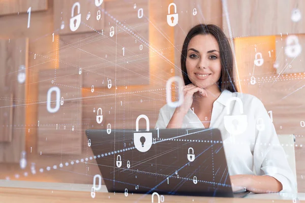 Attraktiv forretningskvinde i hvid skjorte på arbejdspladsen arbejder med laptop til at forsvare kundens cybersikkerhed. Begrebet kundeinformationsbeskyttelse. Hængelås hologram over kontorbaggrund. - Stock-foto