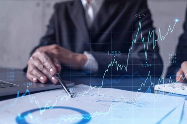 Borsa davranışlarını tahmin etmek için tarihi verileri araştıran iki tüccar ve kadın. İnternet ticareti konsepti. Belgelerin olduğu masanın üzerinde eski ve finansal hologram şeması