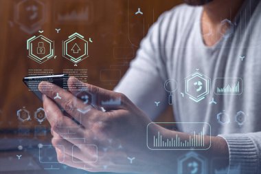 Programcı elinde akıllı bir telefon tutuyor ve tamamen yeni bir hizmet sunmak için yenilikçi bir uygulamayı test ediyor. Yakın çekim. Hologram teknik grafikleri. Dev takım kavramı.