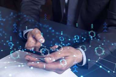 Programcı elinde akıllı bir telefon tutuyor ve tamamen yeni bir hizmet sunmak için yenilikçi bir uygulamayı test ediyor. Yakın çekim. Hologram teknik grafikleri. Dev takım kavramı. Resmi giysi.