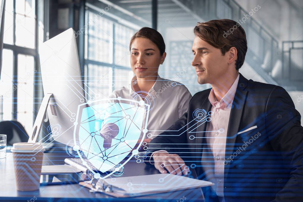 Businessman and businesswoman working together to protect clients confidential information and cyber security. IT hologram padlock icons over office background with panoramic windows.