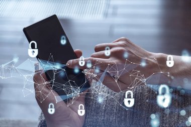 Bir programcı, bir siber güvenliği hacker saldırılarından korumak ve müşterilerinin gizli verilerini kaydetmek için akıllı telefonuyla internete giriyor. Yazan ellerin üzerine asma kilit hologramı simgeleri.